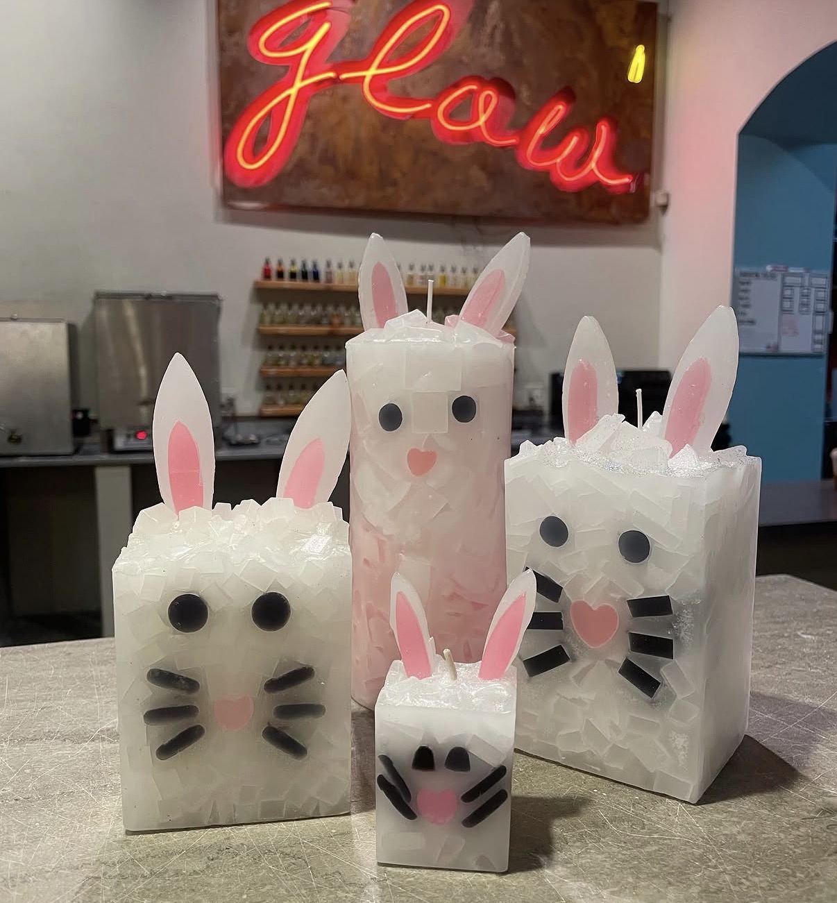 Adorable bunny candles in front of the Glow neon sign