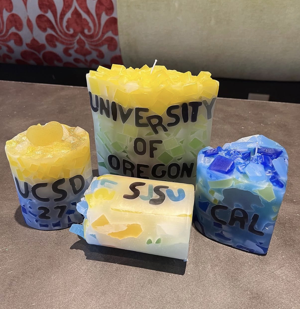 Custom university candles including University of Oregon, UCSD, SJSU and Cal made at Glow Candle Lounge