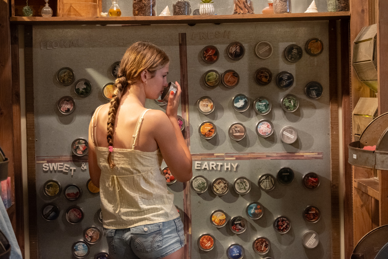 Guest smelling fragrance oils at the scent wall at Glow Candle Lounge